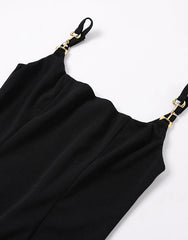 Black dress with gold straps on a white background