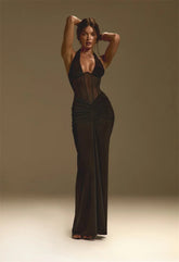 Woman wearing a black evening gown against a plain background