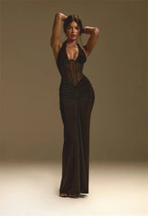 Woman wearing a black evening gown against a plain background