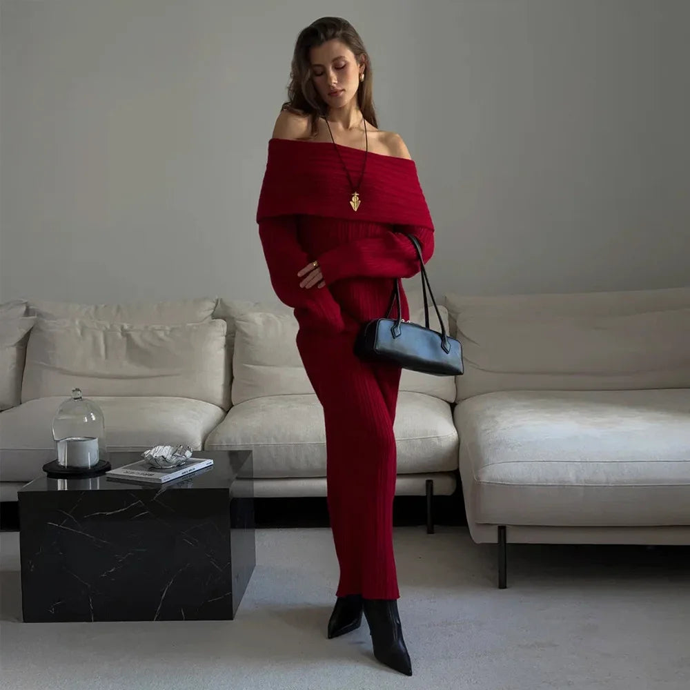 Woman in a red outfit holding a black handbag in a modern living room.