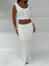 White scalloped edge knit crop top and maxi skirt set worn by a model against a white background.