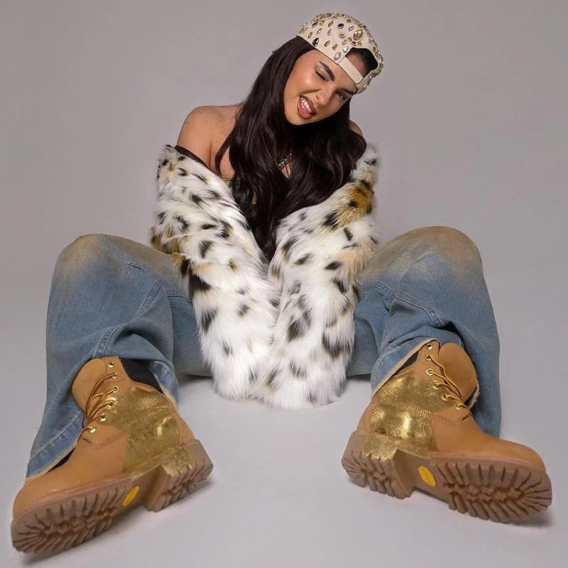 Person wearing gold boots, a leopard print hat, and a patterned coat on a gray background