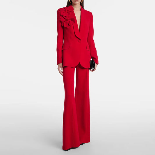 Red suit jacket with three dimensional flower embellishment and flared trousers