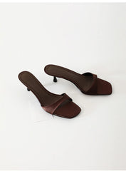 Pair of brown high-heeled sandals on a white background