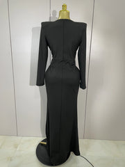 Black evening gown on a mannequin against a plain background
