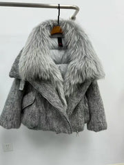 Gray coat with fur collar on a hanger against a white wall