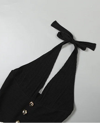 Black halter top with bow detail on a light gray background