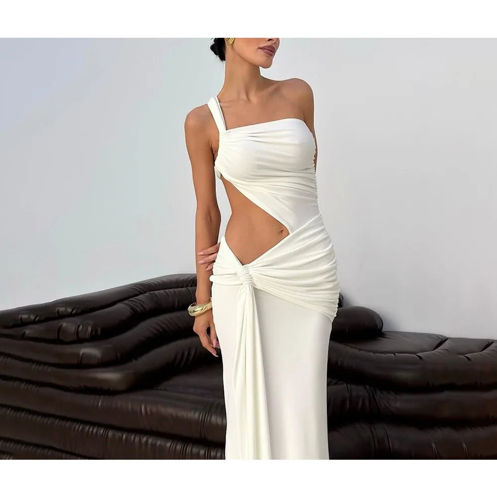 Woman wearing a white one-shoulder dress with cut-out design, standing against a plain background.