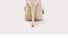 Close-up of a beige high-heeled shoe on a light gray background