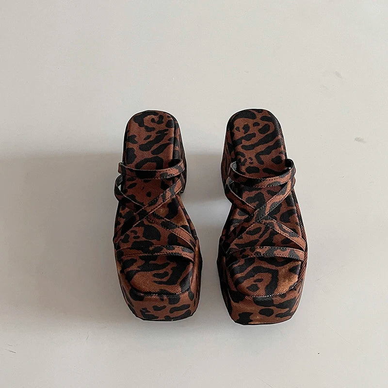 Pair of leopard print sandals on a white background