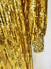 Close-up of a gold sequin fabric on a white background