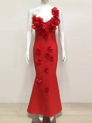 Red evening gown with floral embellishments on a mannequin against a white background