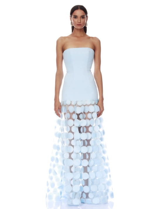 Woman wearing a light blue strapless gown with a unique patterned skirt on a white background