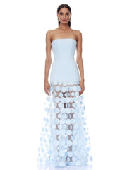 Woman wearing a light blue strapless gown with a unique patterned skirt on a white background