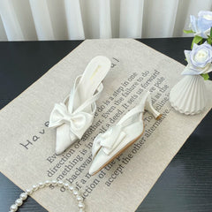 White bow shoes on a textured surface with text and decorative elements.