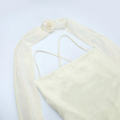 Cream-colored bikini top with thin straps on a light gray background