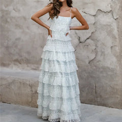Woman wearing a white lace dress against a textured wall.
