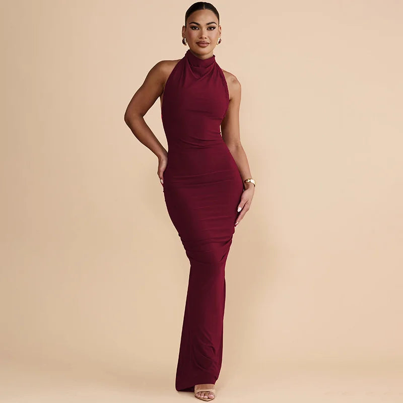 Woman wearing a burgundy halter neck dress on a beige background