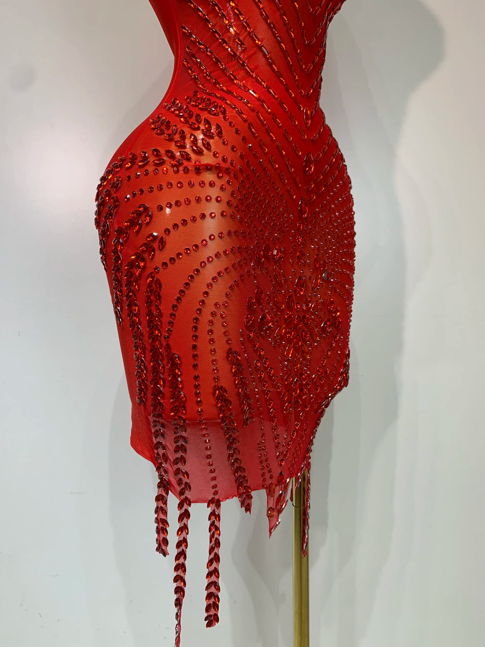 Red beaded dress on a mannequin against a white background