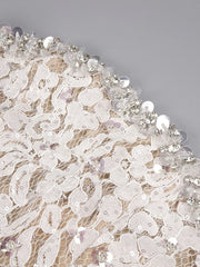 Close-up of lace fabric with beads on a gray background