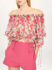 Close-up of the off-shoulder neckline and ruffled detail on a floral print blouse.