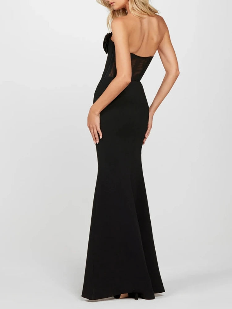 Black evening gown with open back on a white background