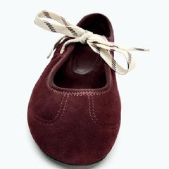 Close-up of burgundy faux suede round toe ballet flats showing lace detail.
