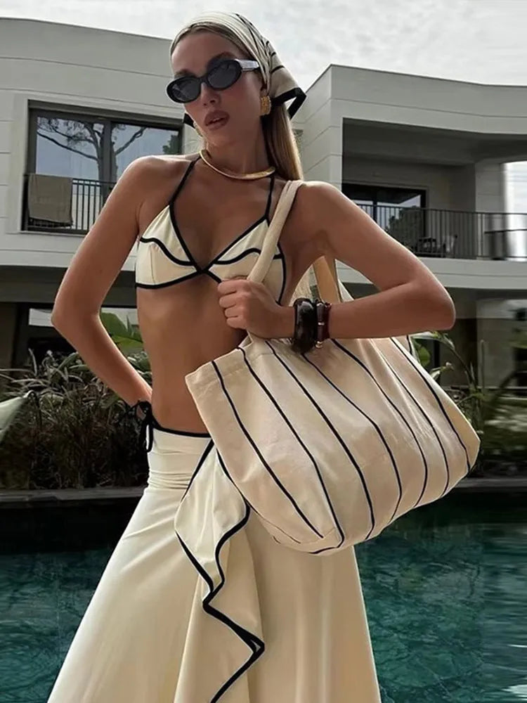 Close-up of a white bikini top and skirt with contrast trim detail.
