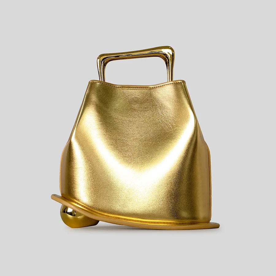 Gold handbag with a handle on a light gray background