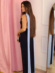 Back view of a two-tone black and light blue halter maxi dress with draped fabric.