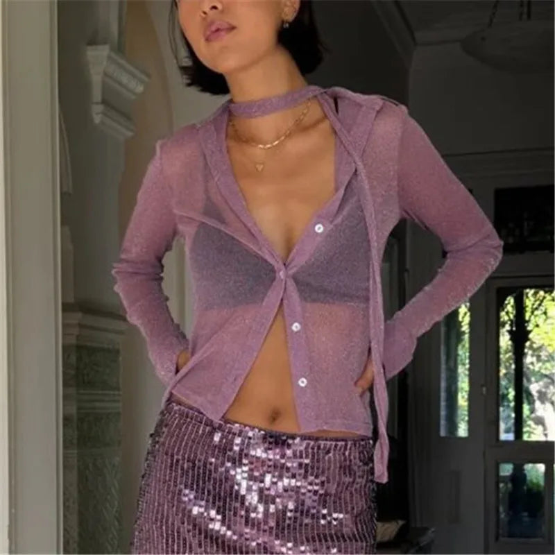 Woman wearing a sheer purple cardigan over a sequin skirt indoors.