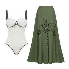 White one-piece swimsuit with green trim and matching green midi skirt with palm cutouts