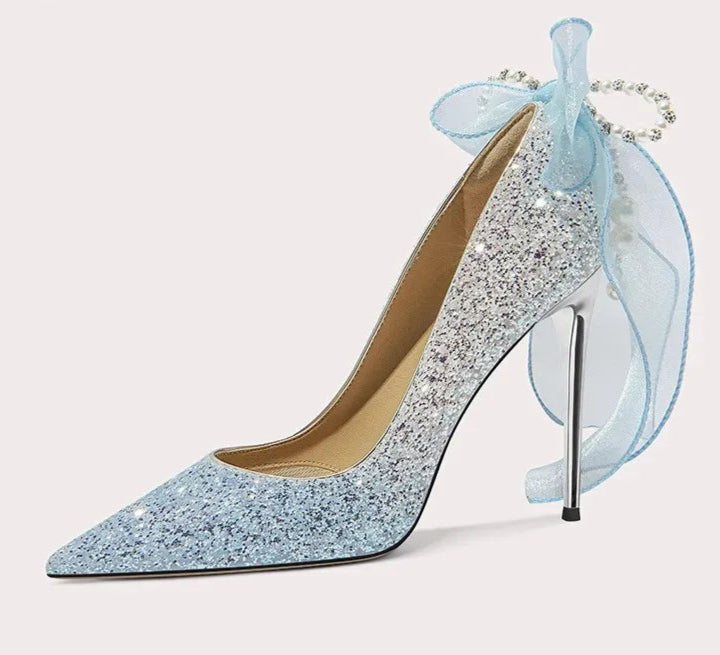 Sparkly high-heeled shoe with a decorative bow on a white background