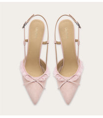Pair of pink pointed-toe heels with bow detail on a white background