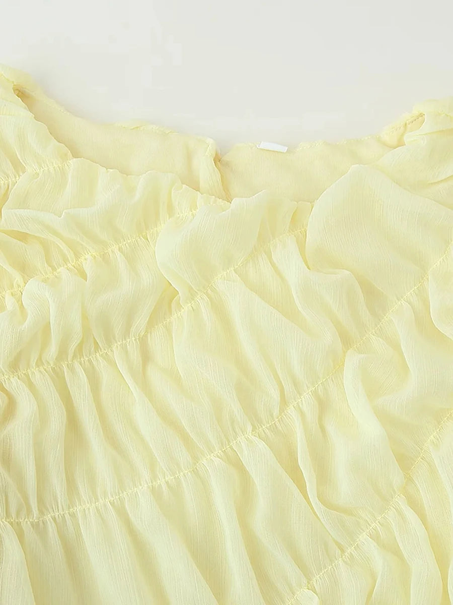 Close-up of light yellow fabric with ruffled texture on a white background