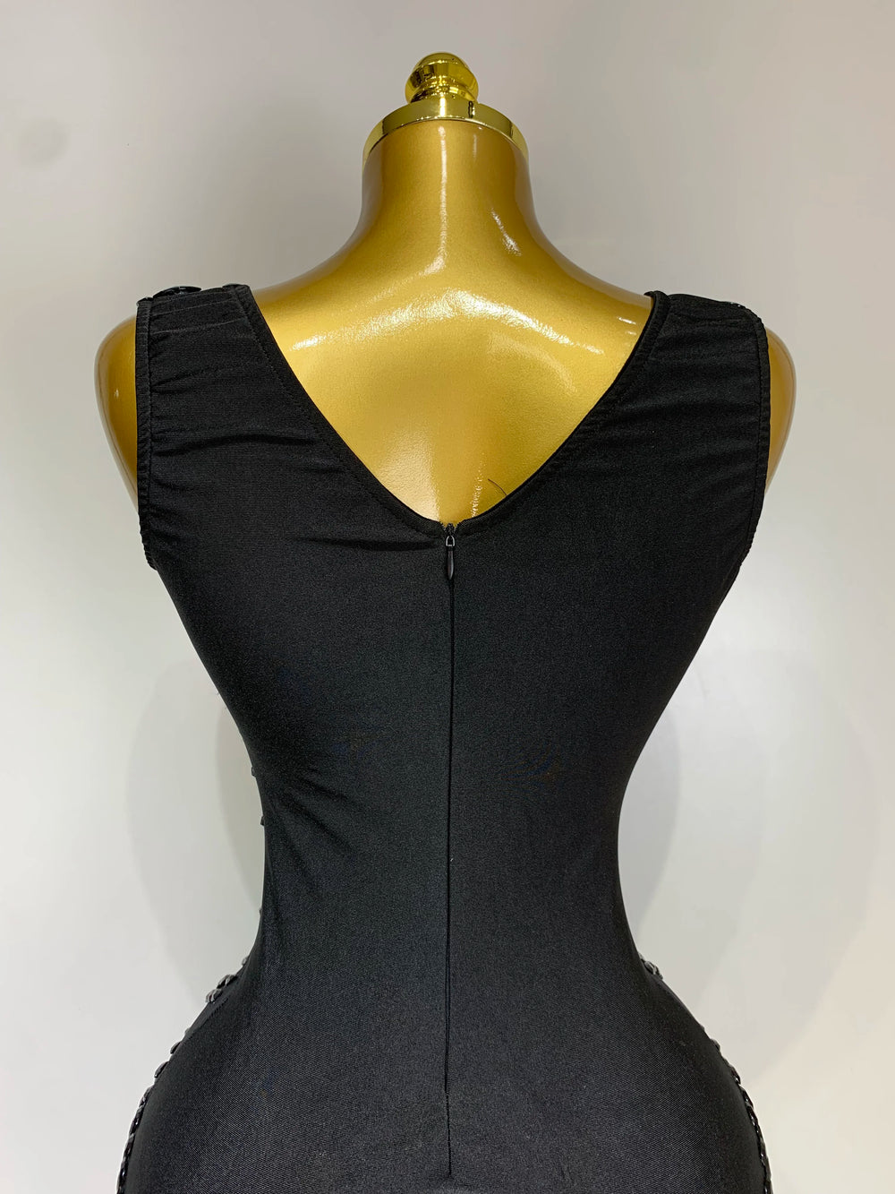 Black dress on a mannequin against a white background