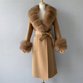Beige coat with fur cuffs and collar on a mannequin against a gray background