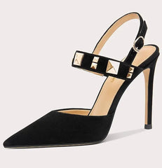 Black high-heeled shoe with studded detail on a light gray background