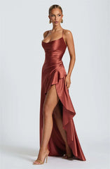 Woman wearing a red satin dress with a slit on a white background