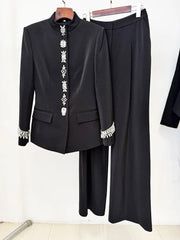Black embellished stand collar jacket and wide leg pants suit displayed on hangers
