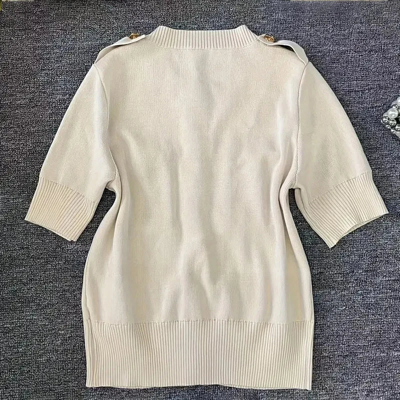 Beige sweater dress on a textured gray surface