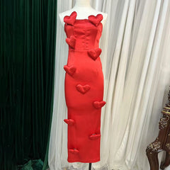 Red dress with heart designs on a mannequin against a white curtain background