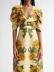 Woman wearing a floral dress with yellow and green flowers on a plain background