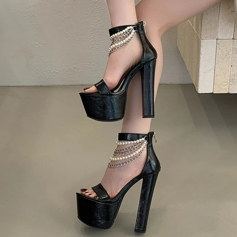 Woman wearing black chunky heel platform sandals with chain detail