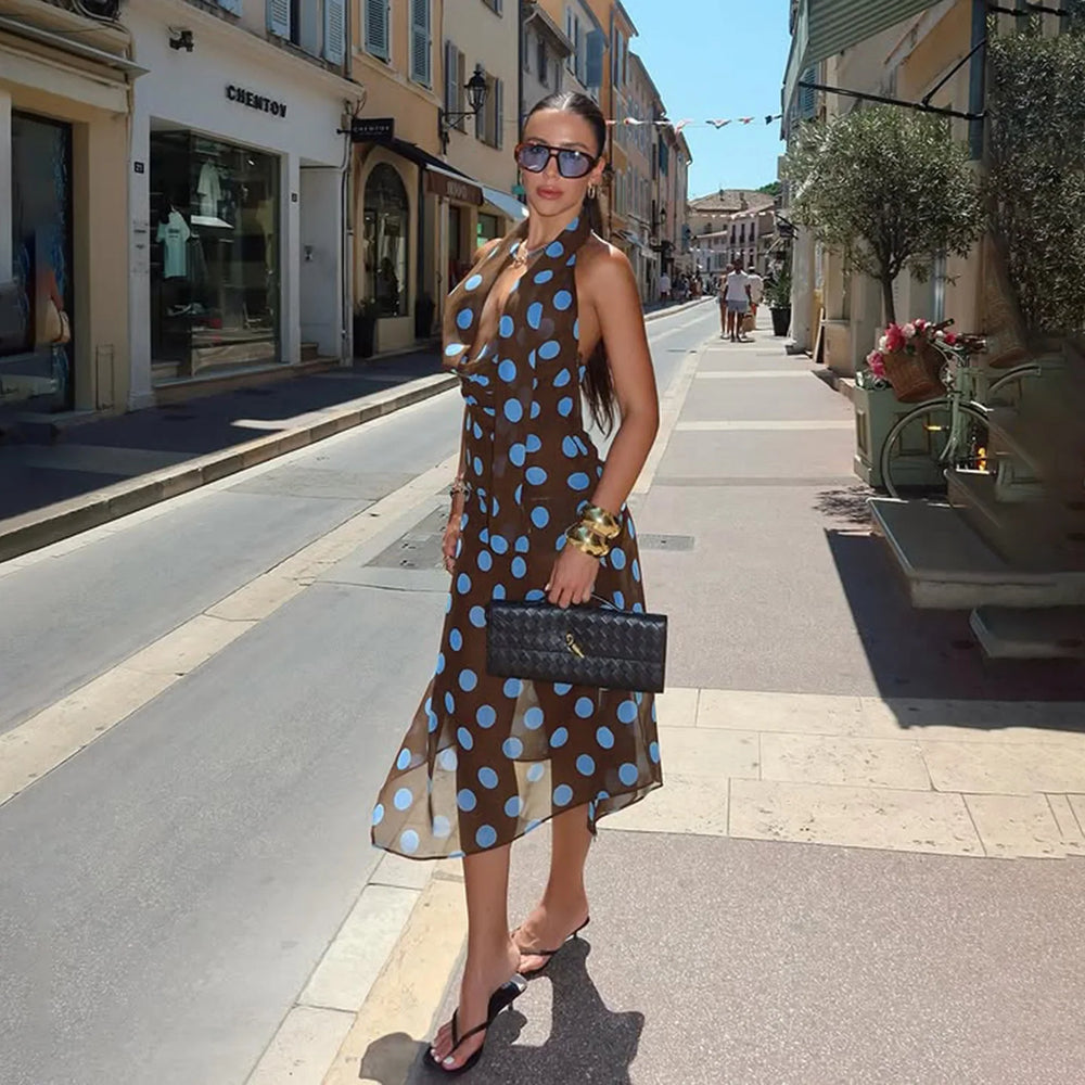 Woman in a polka dot dress standing on a city street