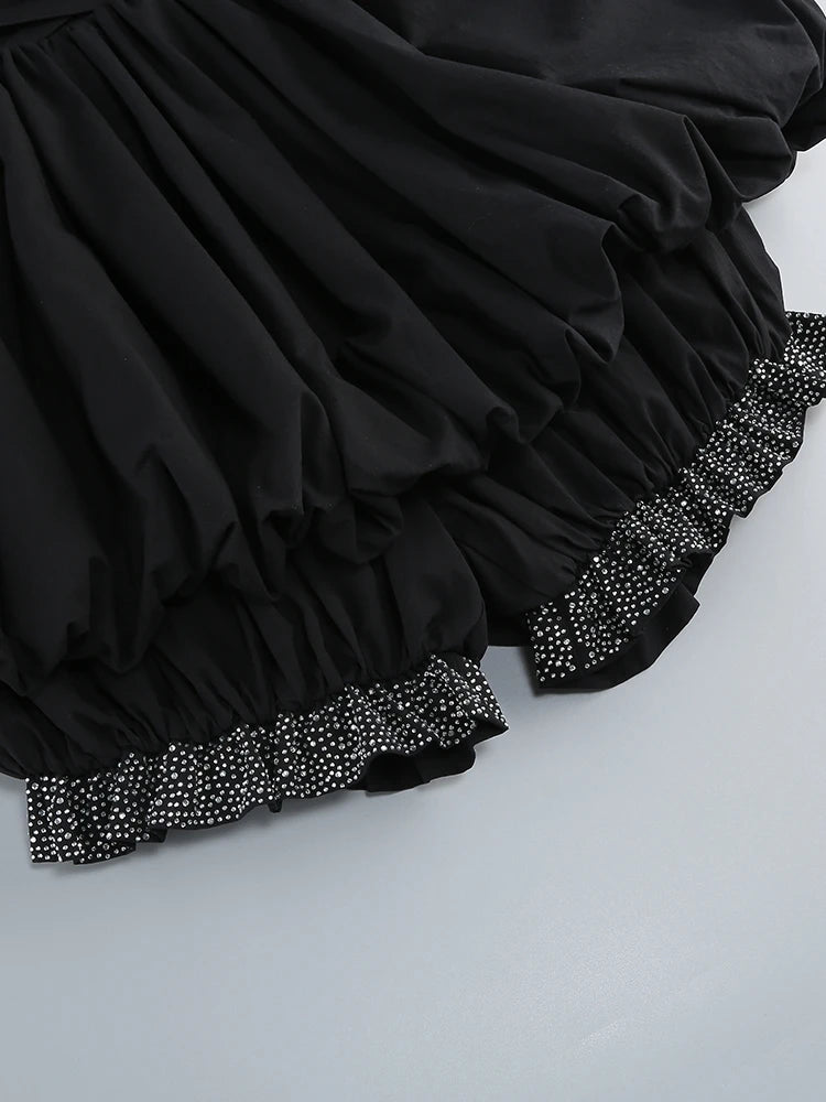 Black skirt with decorative hem on a light gray background