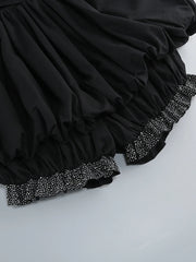 Black skirt with decorative hem on a light gray background