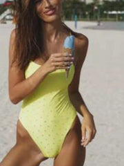 Yellow embellished one-piece swimsuit on a beach