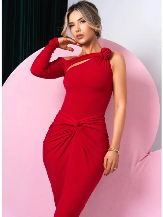 Woman wearing a red dress with a floral detail against a pink and gray background