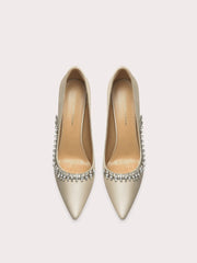 Pair of gold high-heeled shoes with crystal embellishments on a light gray background